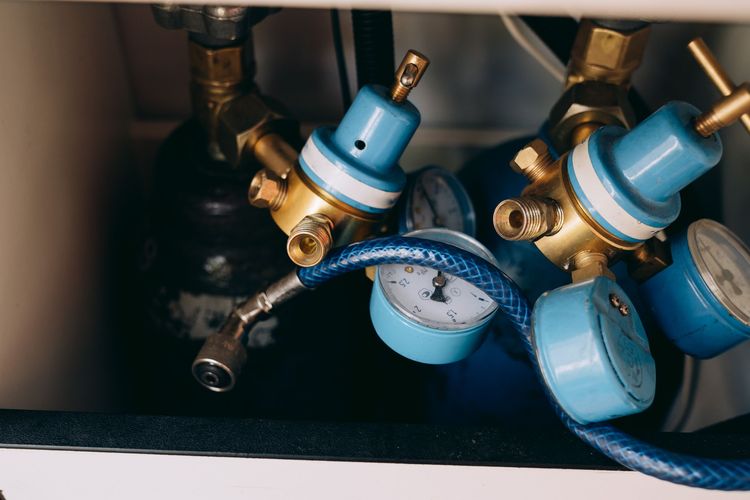 Two gas cylinders fitted with regulators and pressure gauges