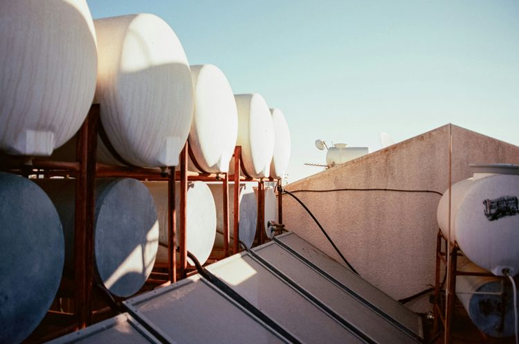 Solar water heater tanks and flat-plate collectors on a roof