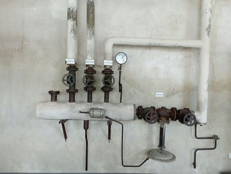 Wall-mounted water pipes with gate valves, a pressure-reducing valve and a gauge